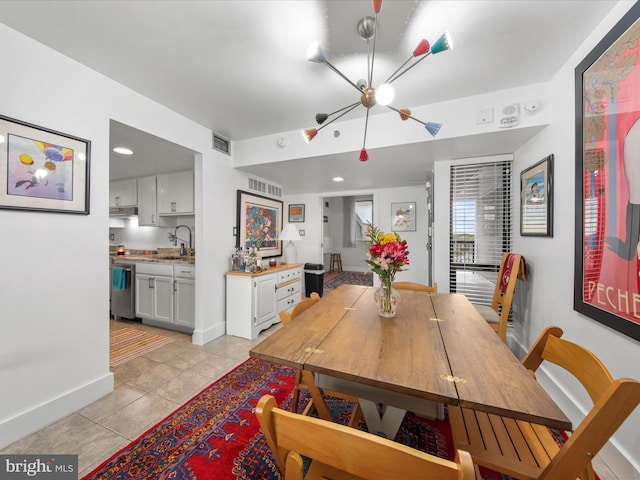 dining area featuring sink and light tile patterned floors