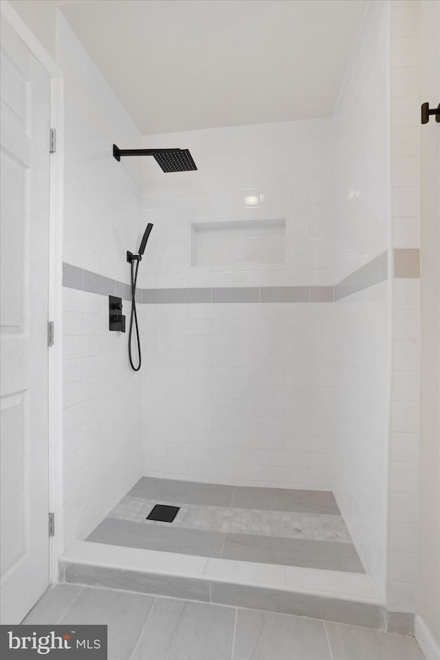 bathroom with tiled shower and tile patterned floors