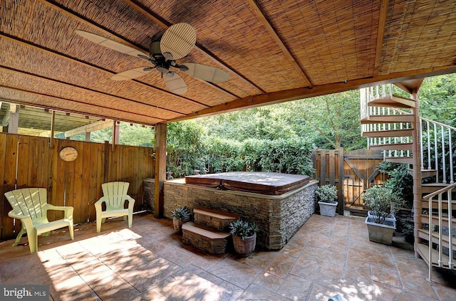 view of patio with ceiling fan and a hot tub