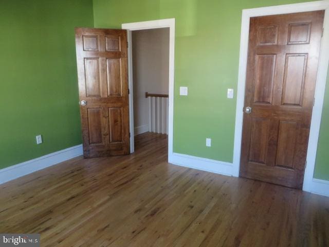 unfurnished bedroom featuring dark hardwood / wood-style flooring