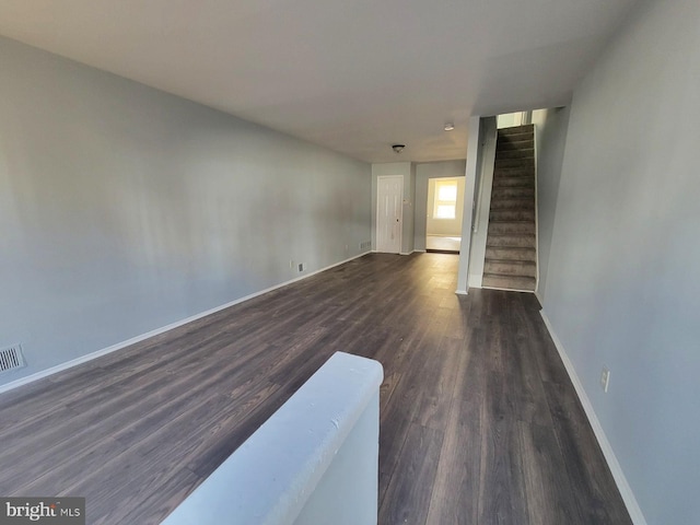 unfurnished living room with dark wood-type flooring