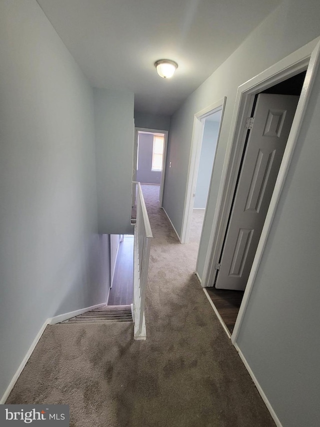 hall with dark colored carpet