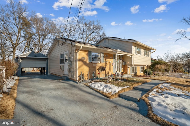 tri-level home featuring a garage and an outdoor structure