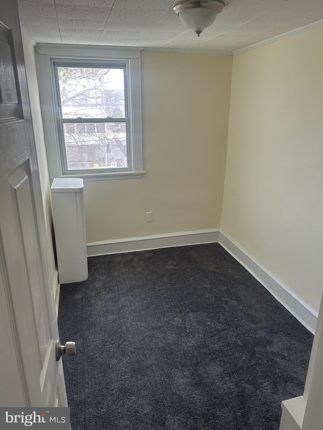 spare room with dark carpet