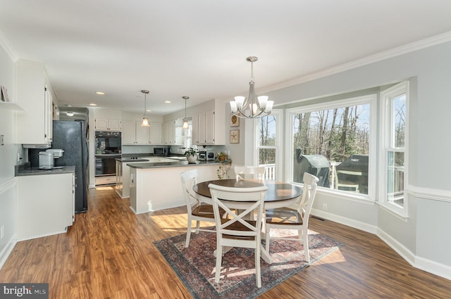 dining space featuring an inviting chandelier, dark wood-type flooring, and ornamental molding