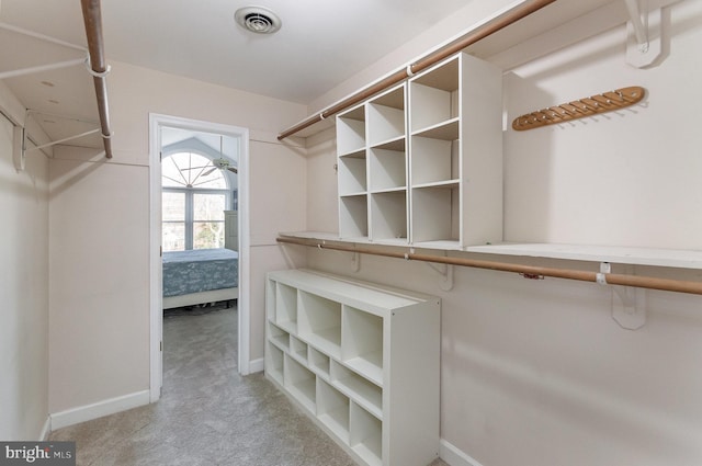 walk in closet featuring light colored carpet