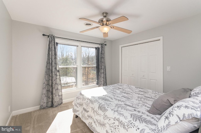 carpeted bedroom with ceiling fan and a closet