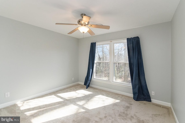 carpeted spare room featuring a healthy amount of sunlight and ceiling fan