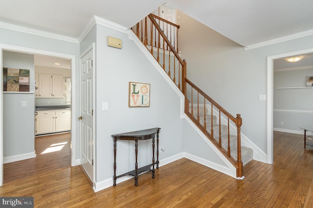 stairway featuring wood-type flooring and crown molding