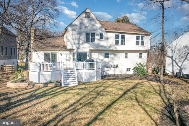 rear view of property with a wooden deck and a lawn