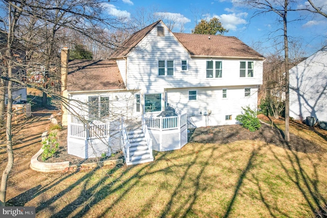 back of property featuring a wooden deck and a yard