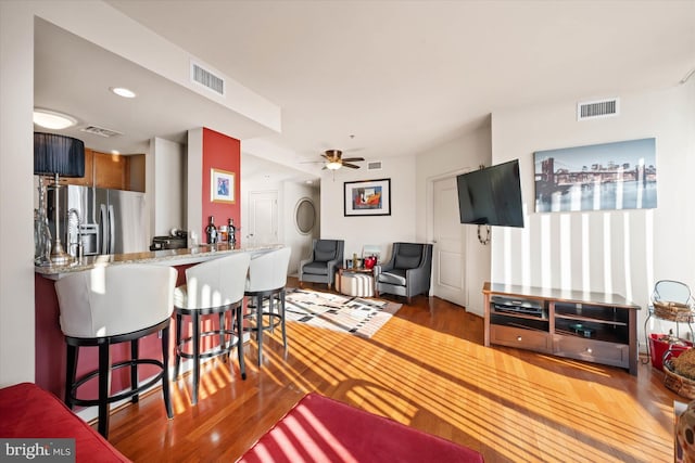 living room featuring dark hardwood / wood-style flooring and ceiling fan