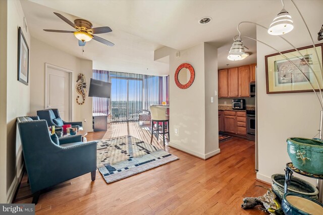105 Christina Landing Dr Unit 905, Wilmington, DE 19801 - living room featuring a wall of windows, ceiling fan, and light wood-type flooring