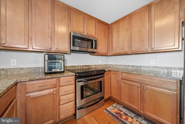 105 Christina Landing Dr Unit 905, Wilmington, DE 19801 - kitchen featuring appliances with stainless steel finishes, light wood-type flooring, and light stone counters