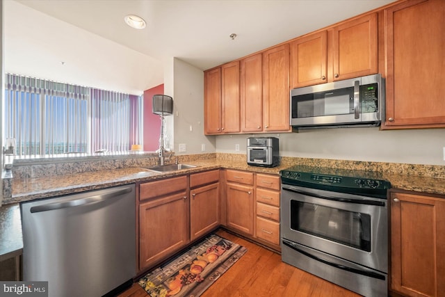 105 Christina Landing Dr Unit 905, Wilmington, DE 19801 - kitchen with light stone countertops, appliances with stainless steel finishes, sink, and light hardwood / wood-style floors