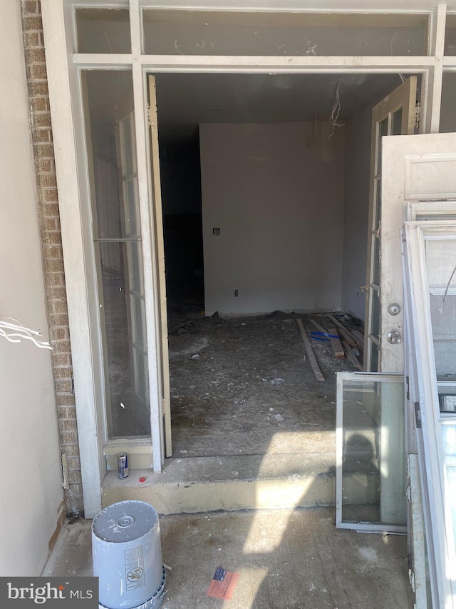 view of exterior entry featuring a garage and brick siding