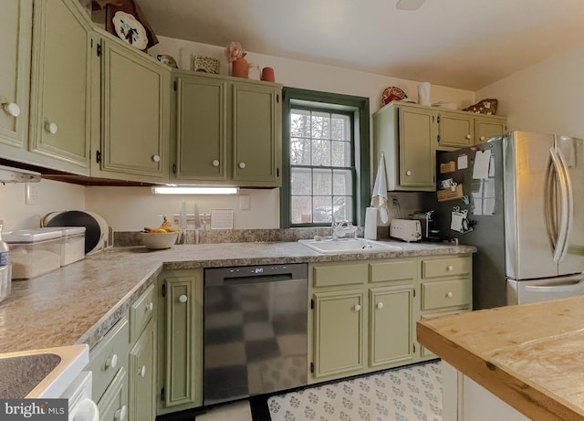 kitchen featuring dishwasher, sink, green cabinets, and stainless steel refrigerator