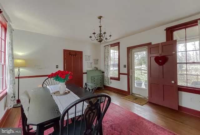 dining area with a notable chandelier, light hardwood / wood-style flooring, and a wealth of natural light