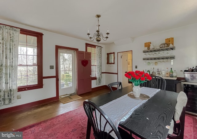 dining area with indoor bar, hardwood / wood-style floors, beverage cooler, and a chandelier