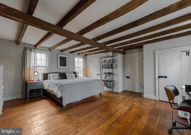 bedroom with wood-type flooring and beamed ceiling