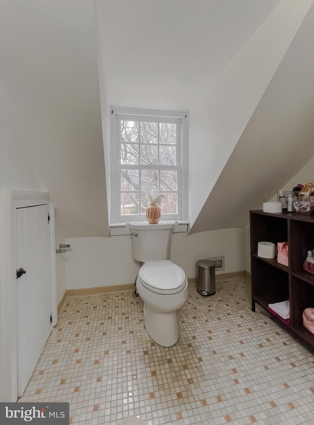 bathroom with lofted ceiling and toilet