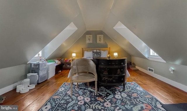 bedroom with wood-type flooring and vaulted ceiling