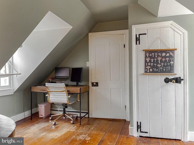 home office featuring lofted ceiling and hardwood / wood-style floors