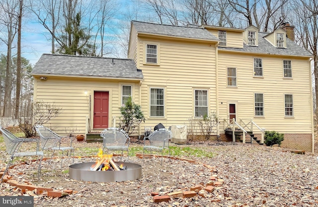 back of house with a fire pit