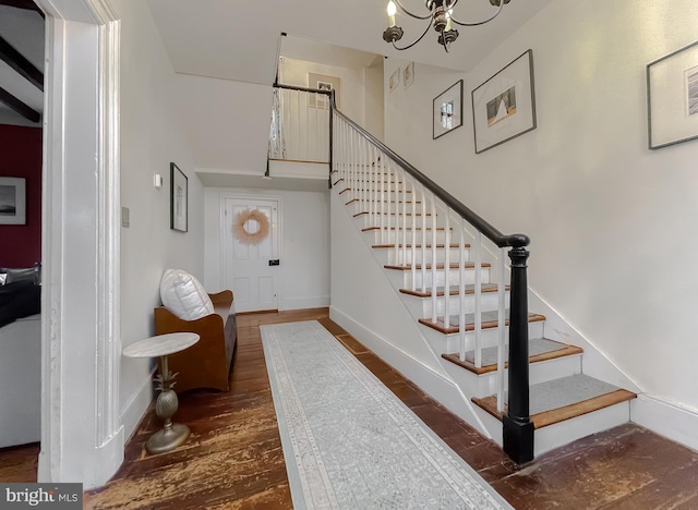 stairs featuring hardwood / wood-style flooring and a notable chandelier