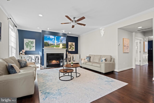 living room featuring dark wood-type flooring, ornamental molding, and ceiling fan