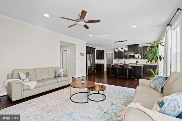 living room featuring crown molding, ceiling fan, dark hardwood / wood-style flooring, and sink