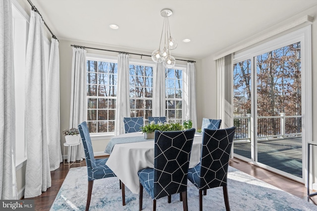 dining area with dark hardwood / wood-style flooring and an inviting chandelier