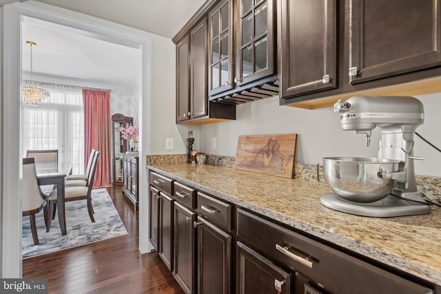 kitchen featuring dark hardwood / wood-style floors, light stone countertops, and dark brown cabinets