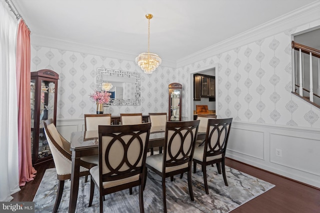 dining area with an inviting chandelier, ornamental molding, and dark hardwood / wood-style floors