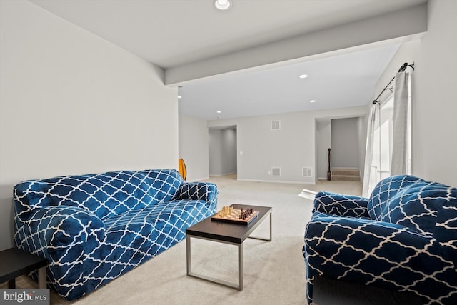 carpeted living room with beam ceiling