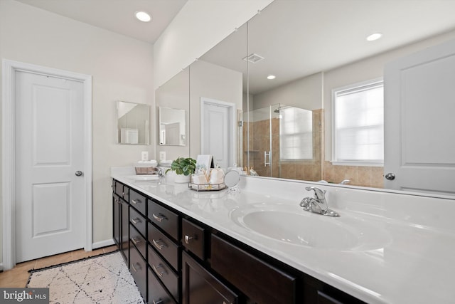 bathroom with tile patterned floors, an enclosed shower, and vanity