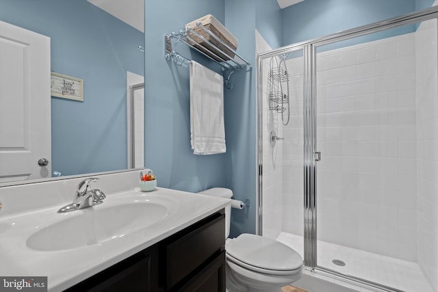 bathroom with vanity, a shower with shower door, and toilet