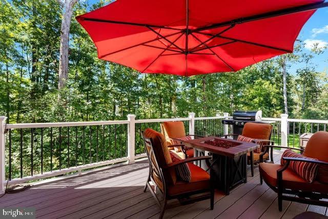 deck with grilling area and a fire pit