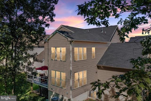 back house at dusk with a balcony