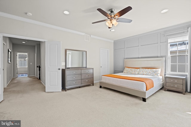 bedroom with ornamental molding, light colored carpet, and ceiling fan