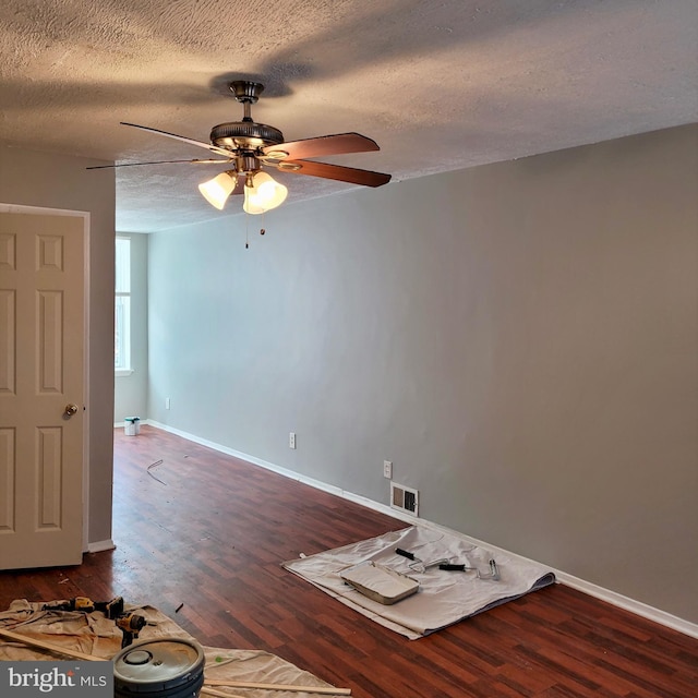 empty room with ceiling fan, a textured ceiling, and dark hardwood / wood-style flooring