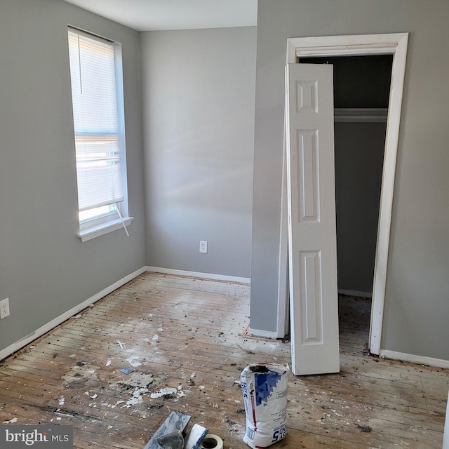 unfurnished bedroom with multiple windows and a closet