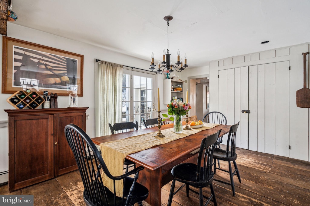 dining room with a baseboard radiator, dark wood-type flooring, and a chandelier