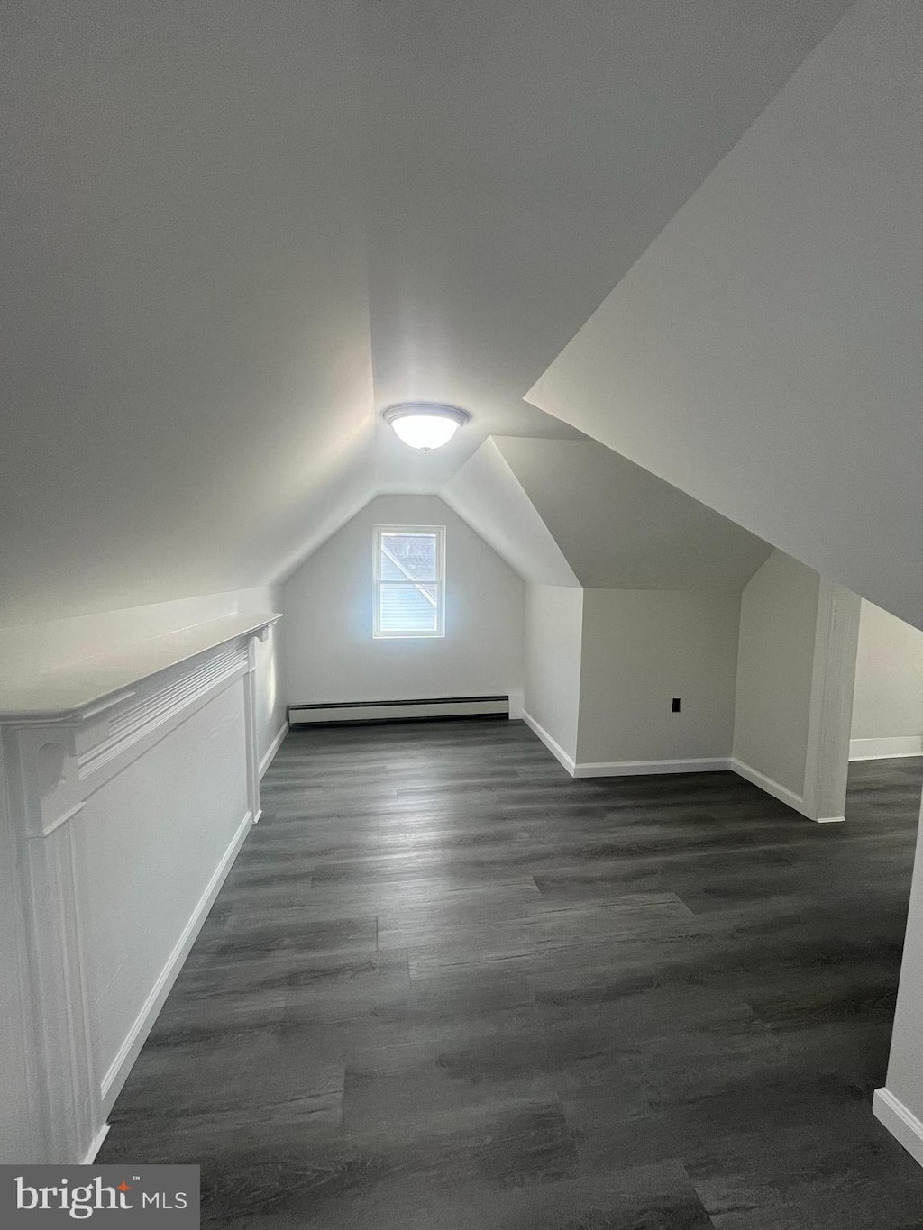 bonus room featuring vaulted ceiling, a baseboard heating unit, and dark hardwood / wood-style floors