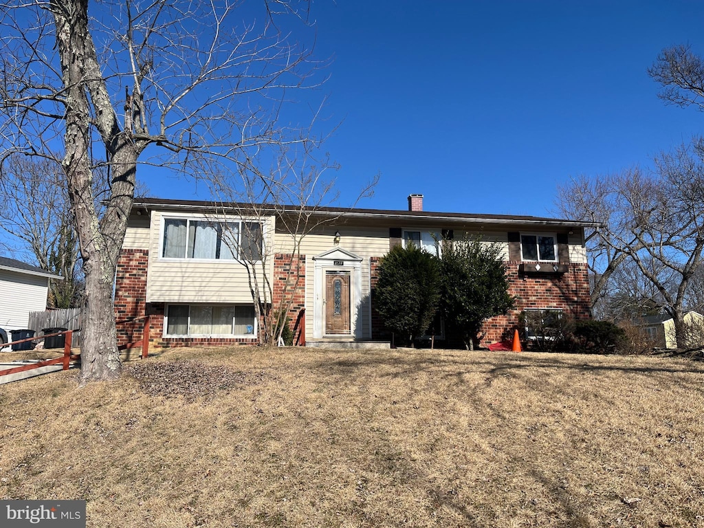 raised ranch featuring a front lawn