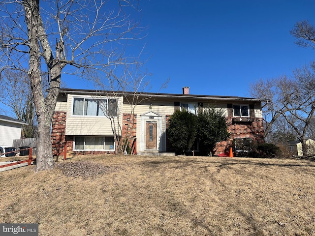 raised ranch featuring a front lawn