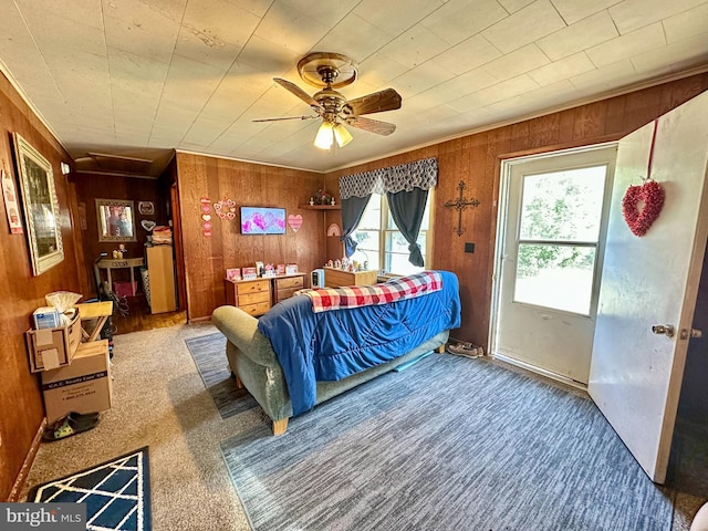 bedroom with multiple windows, wooden walls, and carpet flooring