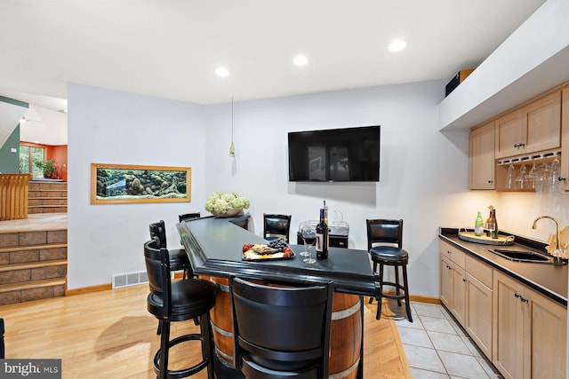 interior space featuring light wood-type flooring, sink, and light brown cabinets