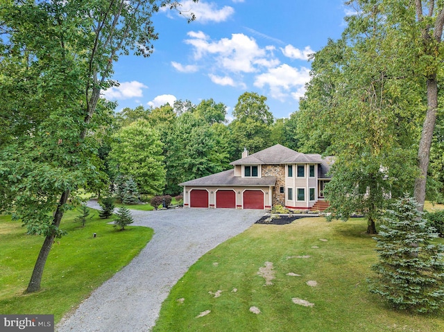 raised ranch with a garage and a front lawn