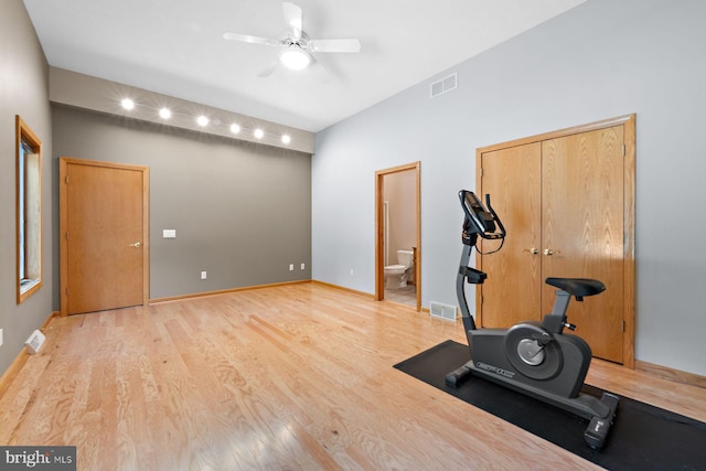 workout room with ceiling fan and light wood-type flooring